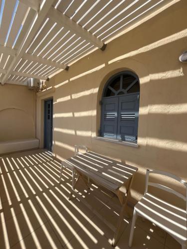 a bench sitting on the side of a building with a window at Leon Lux Apartment in Perivolos