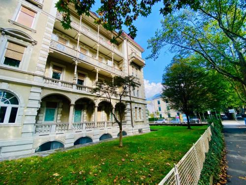 a building with a grass yard in front of it at Spazioso e accogliente nel centro di Merano in Merano