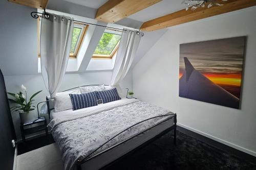 a bedroom with a bed and two windows at Apartmán u pilotky in Poděbrady