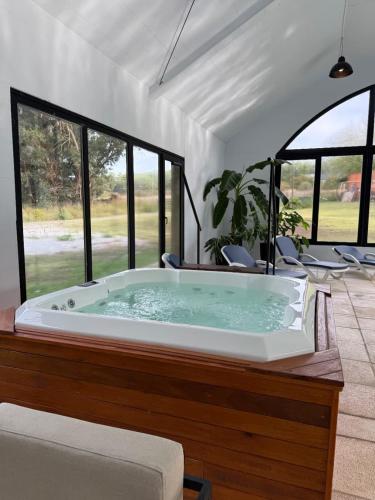 a hot tub in a room with windows at Mellmell en la Sierra in Tandil