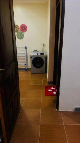a door to a room with a washing machine on the floor at Robchen homes in Entebbe
