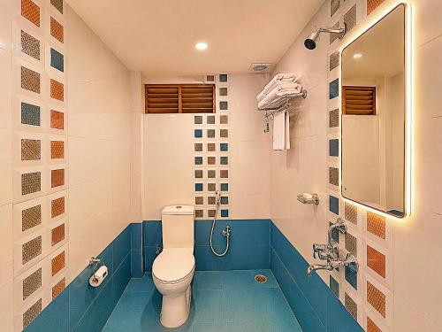 a bathroom with a toilet and a tub at Blue Lily Beach Resort in Puri