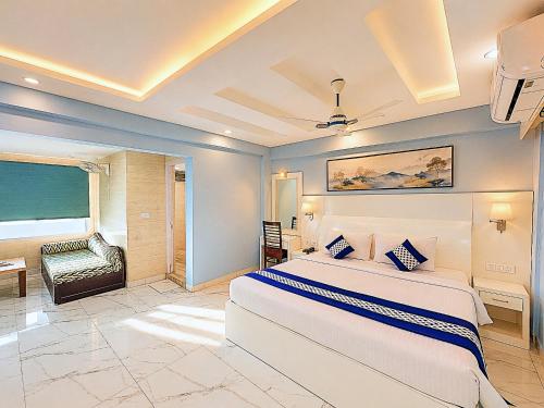 a bedroom with a large bed and a chair at Blue Lily Beach Resort in Puri