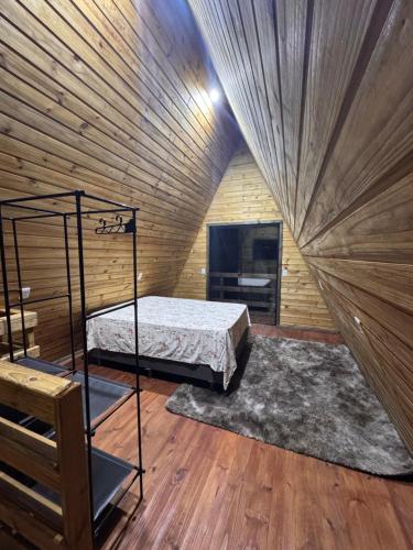 a bedroom with a bed in a wooden wall at Cabanas da zimba in Imbituba