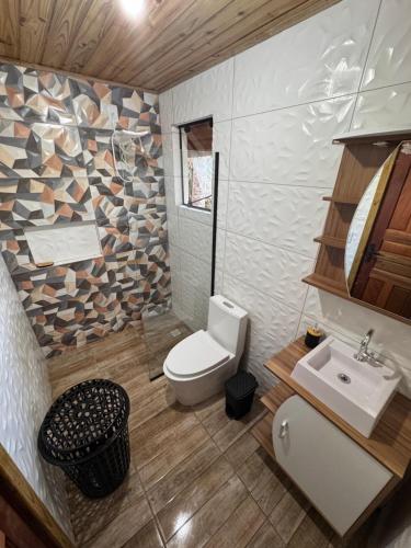 a bathroom with a toilet and a sink at Cabanas da zimba in Imbituba