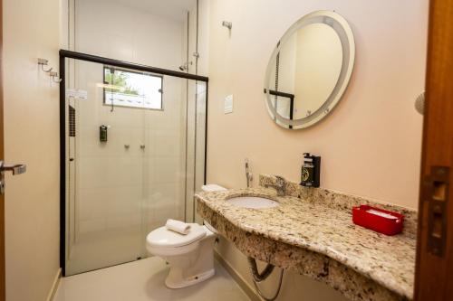 a bathroom with a toilet and a sink and a mirror at Rancho das Pedras Itaberá in Itaberá