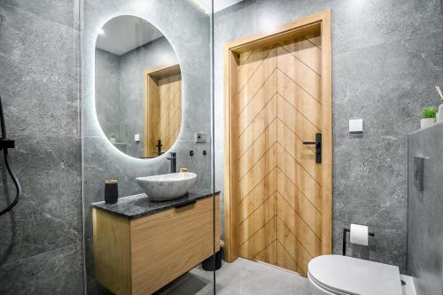 a bathroom with a sink and a mirror at Apartamenty Przystanek Bańska in Bańska Niżna