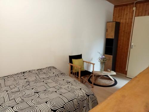 a bedroom with a black and white bed and a chair at Villa René in Lacanau