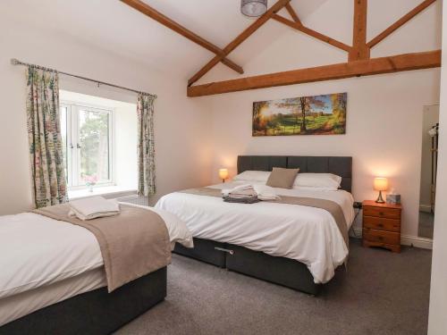 a bedroom with two beds and a window at Ploughman's Rigg in Harrogate
