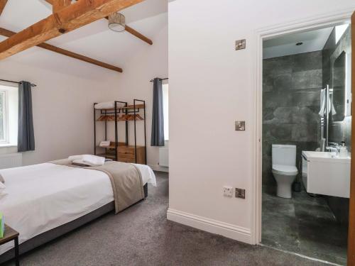 a bedroom with a bed and a sink and a toilet at Ploughman's Rigg in Harrogate