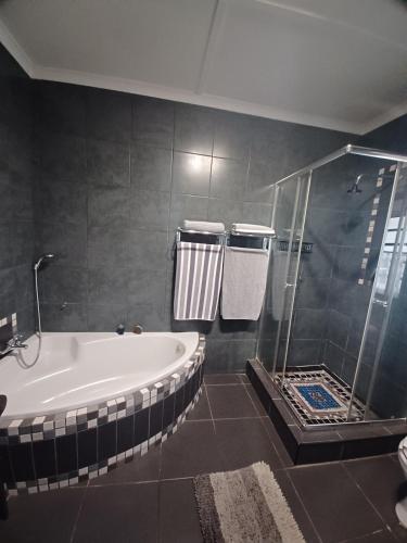 a bathroom with a bath tub and a shower at Duncan Garden Cottage in Brakpan