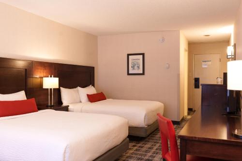 a hotel room with two beds and a desk at Marmot Lodge Jasper in Jasper