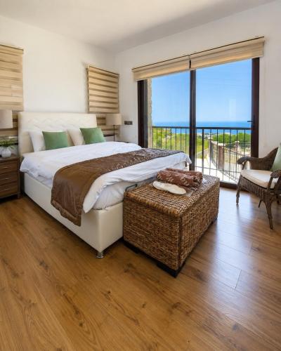 a bedroom with a large bed and a balcony at Bellapais Stone Villa in Kyrenia