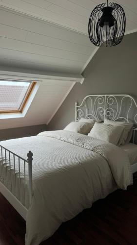 a bedroom with a large white bed with a window at Countryside house by Pairi Daiza in Silly