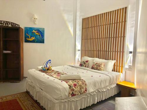 a bedroom with a large bed with a window at Moon Isle Beach Bungalow in Nilaveli