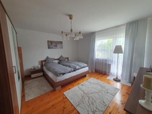 a bedroom with a bed and a large window at White House in Gronów