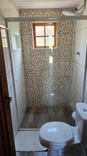 a small bathroom with a toilet and a window at Cabana Família Lima in Urubici