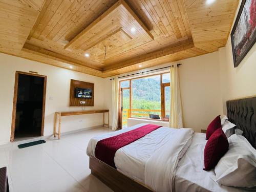 a bedroom with a large bed and a large window at Hotel Deluxe Inn Manali in Manāli