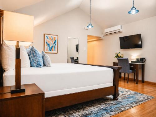 a bedroom with a large bed and a desk at Manta Lodge and Dive Centre in Speyside