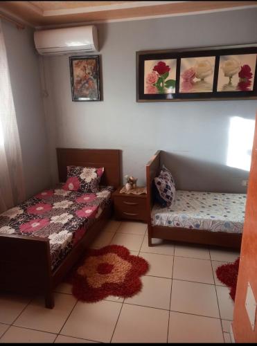 a bedroom with two beds and a couch and rugs at Oumayma in Sousse