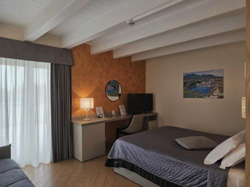 a bedroom with a bed and a desk with a computer at Porto Di Claudio in Fiumicino