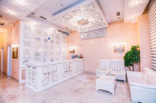uma sala de estar com mobiliário branco e uma escadaria em Admiral Hotel em Baku