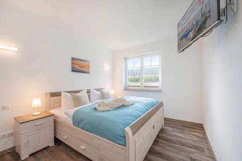 a bedroom with a bed with blue sheets and a window at Ferienwohnung Haffblick in Kamminke