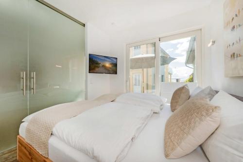 a bedroom with a large white bed and a window at Ferienhaus Kuschelnest in Kamminke