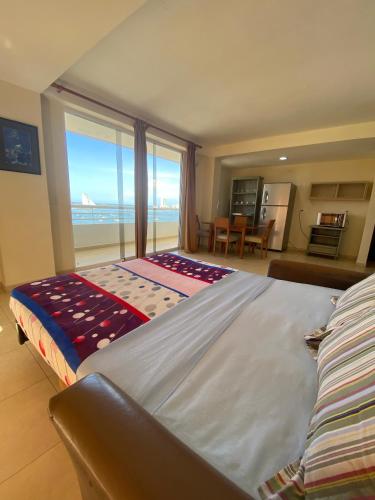 a bedroom with a large bed with a view of the ocean at Beach View Palace in Porlamar