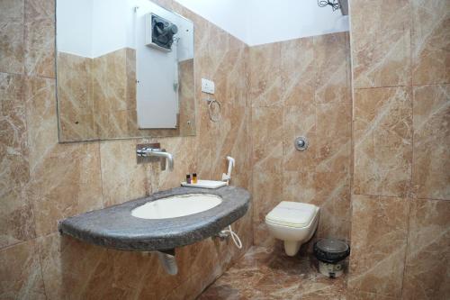 a bathroom with a sink and a toilet at Hotel Vishnu Vilas in Rewa