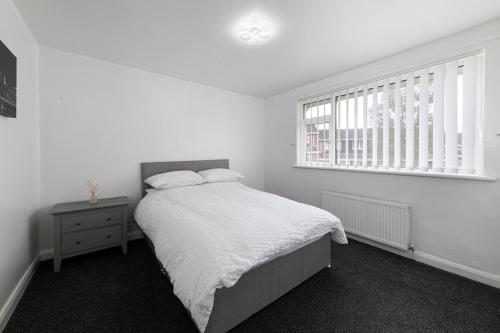 a white bedroom with a bed and a window at Henley Haven in Pelton Fell