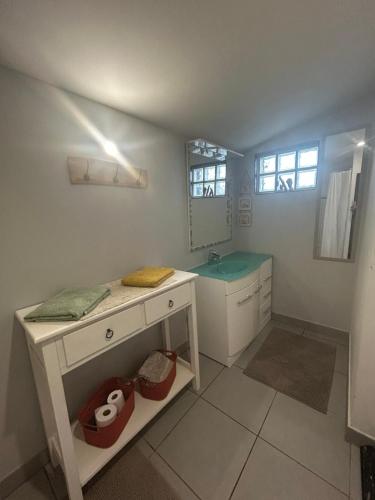 a white bathroom with a sink and a mirror at Gîte en Baie de Somme in Saint-Blimont