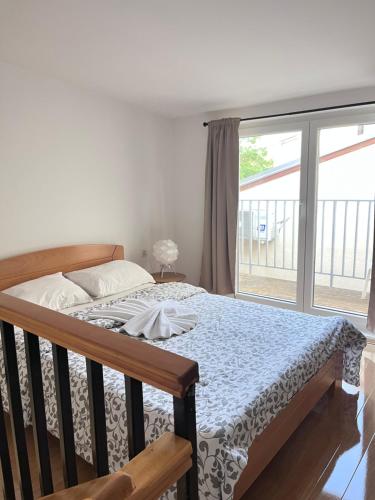 a bedroom with a bed and a large window at Kassiopi River House Novi Sad in Novi Sad