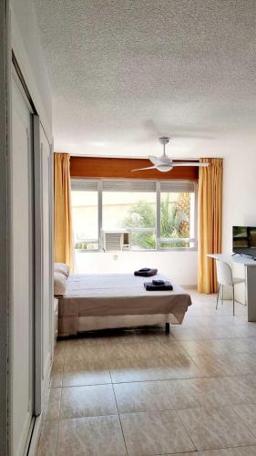 a bedroom with a bed and a large window at Pequeño estudio frente al mar, piscina y parking in Villajoyosa