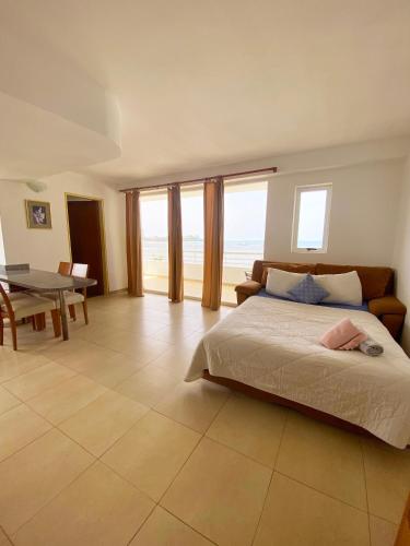 a bedroom with a bed and a table with a view of the ocean at Beach View Palace in Porlamar