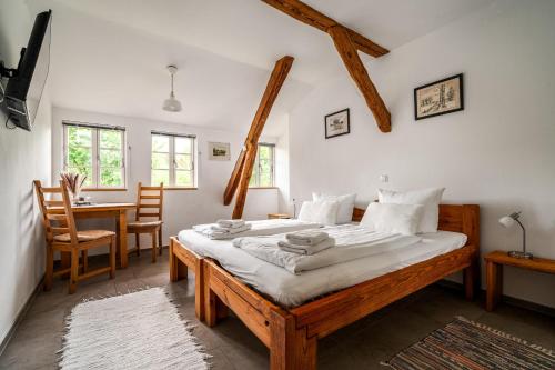 a bedroom with two beds and a table and chairs at Hotel Bolter Mühle - DZ Rapskammer in Rechlin