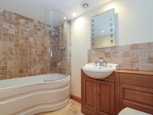 a bathroom with a sink and a toilet and a tub and a sink at Longside in Abergavenny
