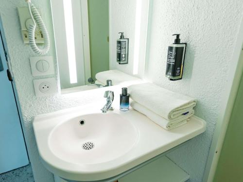 a bathroom with a white sink and a mirror at ibis budget Sète centre in Sète