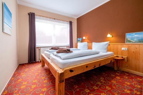 a bed in a room with a large window at Ankerplatz in Thiessow