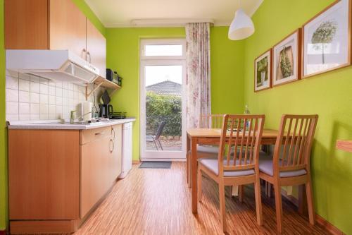 a kitchen with a table and chairs and a window at Ankerplatz in Thiessow