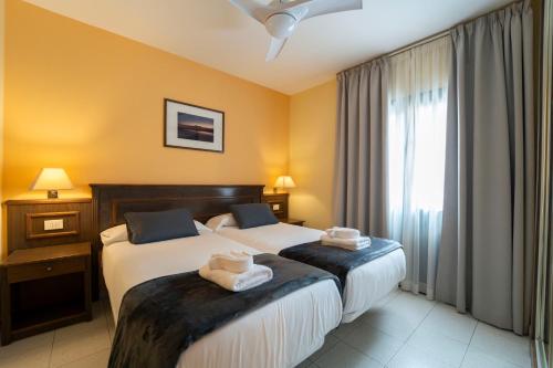 two beds in a hotel room with towels on them at CT Las Tres Palmeras - Valle Gran Rey in Valle Gran Rey
