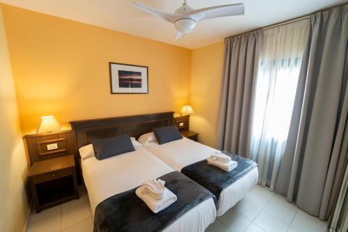 a hotel room with two beds and a window at CT Las Tres Palmeras - Valle Gran Rey in Valle Gran Rey