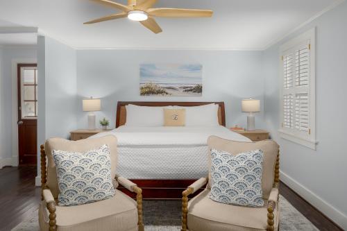 a bedroom with a bed and two chairs at Elizabeth Pointe Lodge in Fernandina Beach