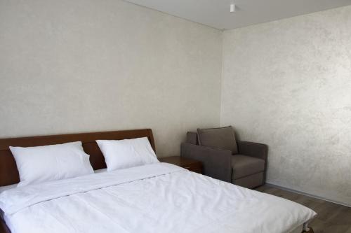 a bedroom with a bed and a chair at СічSich in Kolomiya