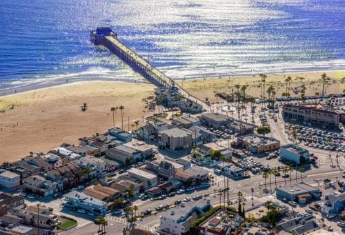 an aerial view of a beach with a pier at 2026 Award Winner, Luxe 2BR, steps to sand & pier, with fire pit, AC and parking in Newport Beach