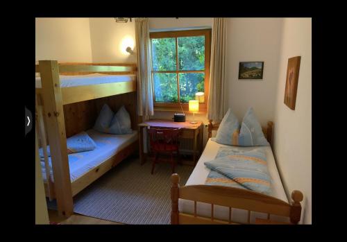 ein Schlafzimmer mit zwei Etagenbetten und einem Schreibtisch in der Unterkunft Grüne Au in St. Wolfgang