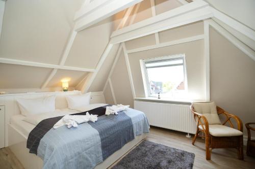 a bedroom with a bed and a chair and a window at Silwai OG in Westerland