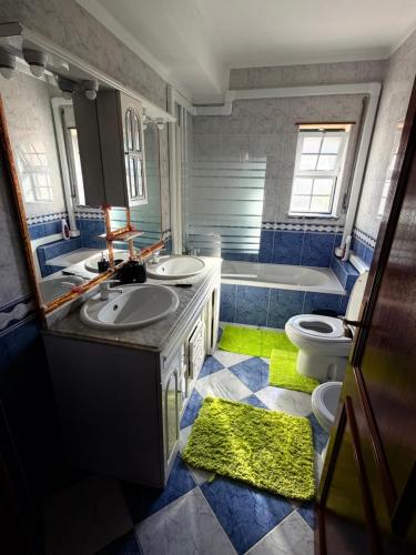 a bathroom with two sinks and a tub and a toilet at Vio's Home in Serra de El-Rei