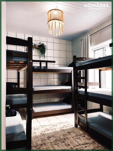 a room with three bunk beds and a chandelier at Nônames Urban Hostel in Florianópolis
