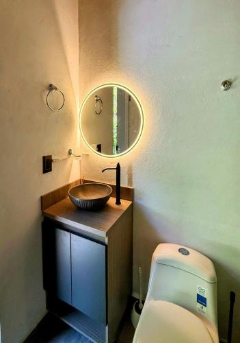 a bathroom with a sink and a toilet and a mirror at Cabaña MonteCristo in El Peñol